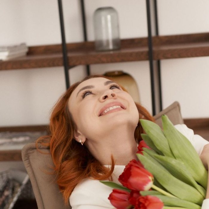 Victoria Soboleva laughing with a bouquet of tulips